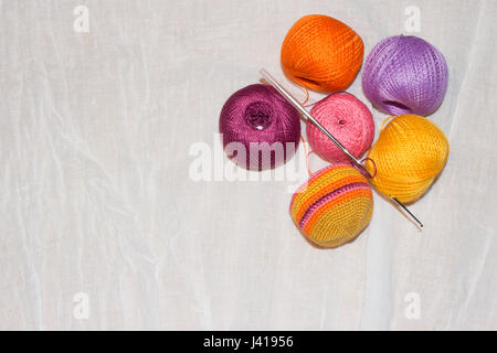 Le crochet en fil de coton coloré et progrès balles sur le fond en lin blanc with copy space Banque D'Images