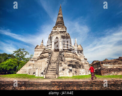 Femme en costume rouge touristiques autour de ruines antiques stupa dans le parc historique d'Ayutthaya, Thaïlande Banque D'Images