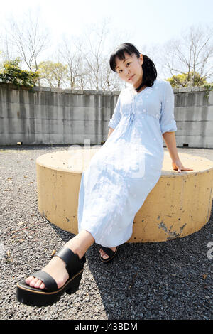 Portrait de jeune japonaise assise sur un banc Banque D'Images