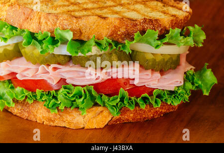 Sandwich sous-marin avec le pain de grains entiers sur plateau en bois Banque D'Images