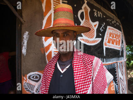 L'homme musulman éthiopien avec un chapeau debout devant sa maison, peint traditionnel Kembata Alaba, Kuito, Ethiopie Banque D'Images