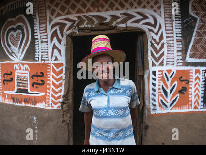 Homme éthiopien avec un chapeau debout devant sa maison, peint traditionnel Kembata Alaba, Kuito, Ethiopie Banque D'Images