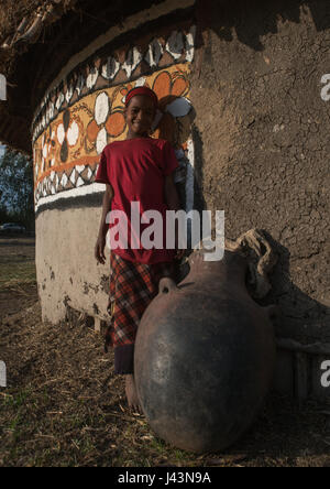 Garçon éthiopien debout devant sa maison, peint traditionnel Kembata Alaba, Kuito, Ethiopie Banque D'Images