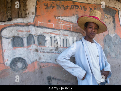 Jeune homme éthiopien avec un chapeau debout devant sa maison, peint traditionnel Kembata Alaba, Kuito, Ethiopie Banque D'Images