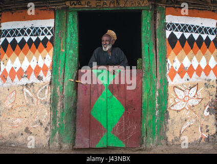 L'homme musulman éthiopien debout devant sa maison, peint traditionnel Kembata Alaba, Kuito, Ethiopie Banque D'Images