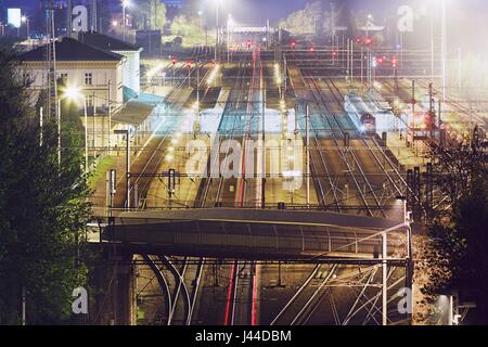 Les feux rouges arrière du train express en gare de nuit. Chocen, République Tchèque Banque D'Images