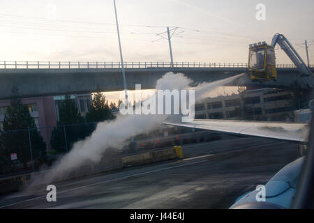 SEATTLE, Washington, USA - JAN 27th, 2017 : processus de dégivrage des ailes d'avion avec de l'antigel avant le décollage pendant une forte tempête de neige. Le dégivrage est important pendant l'hiver ou le matin, vue de l'intérieur de l'avion Banque D'Images