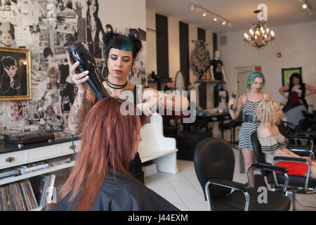 Un coiffeur styling des cheveux d'un client. Banque D'Images