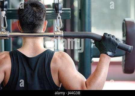 L'homme en Asie est de retour avec le muscle latissimus en machine de sport. Tough guy si fort le muscle dans la salle de remise en forme. Banque D'Images