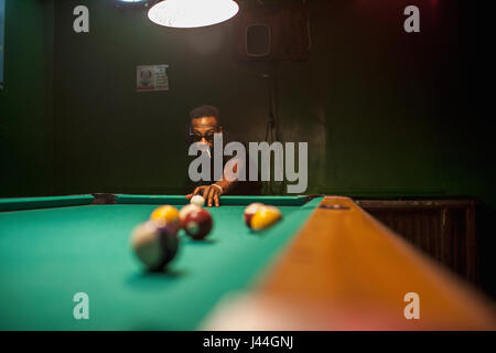 Un jeune homme jouant au billard. Banque D'Images