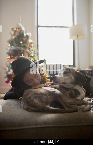 Une jeune femme avec un chien sur un canapé Banque D'Images