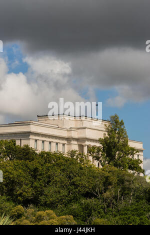 Auckland, Nouvelle-Zélande - le 4 mars 2017 : War Memorial Museum bâtiment derrière la végétation verte sous le ciel nuageux et pluvieux comme vu de Parnell Road. Banque D'Images