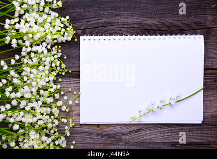 Ordinateur portable avec des feuilles blanc propre sur une surface en bois, vue du dessus Banque D'Images