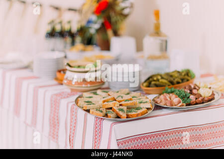 Close up de différentes collations salées et de cornichons dans la poterie ethnique sur une restauration à table banquet hall Banque D'Images