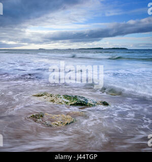 Vue de la plage à l'Whiterocks des Skerries un groupe d'îles rocheuses au large de la côte d'Antrim en Irlande du Nord près de Portrush Banque D'Images