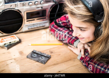 La musique de style rétro avec en-tête de jeune fille à l'écoute de la musique sur boombox avec casque Banque D'Images