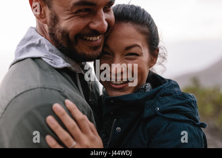 Close up of young couple in love se tenant ensemble à l'extérieur. Jeune homme romantique et faire place au femme dans la campagne. Banque D'Images