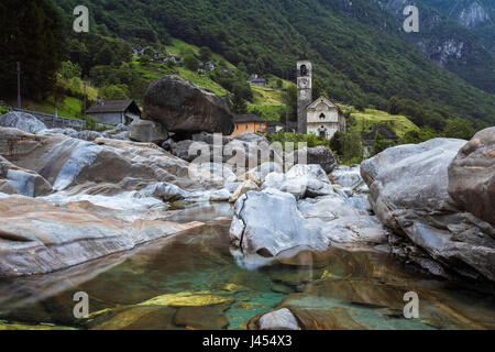 Les roches sur le lit de la rivière Verzasca et l'église de Lavertezzo, Valle Verzasca, Tessin, Suisse. Banque D'Images
