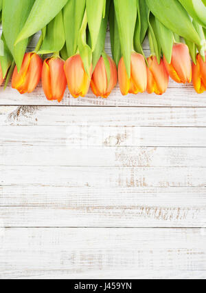 Tulipes rouges sur fond de bois blanc miteux, vue du dessus Banque D'Images