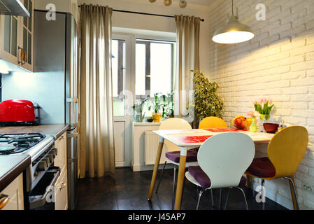 L'intérieur de la cuisine dans un style scandinave avec des meubles blancs et une table à manger Banque D'Images