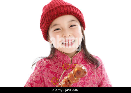 Happy little girl eating les tomates sur des bâtons Banque D'Images