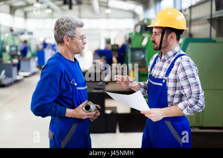 Les apprentis de l'enseignement du génie d'utiliser des machines de traitement des métaux cnc informatisé en usine Banque D'Images