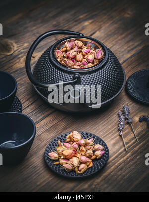 Théière avec boutons de rose au-dessus sur fond de bois vintage Banque D'Images