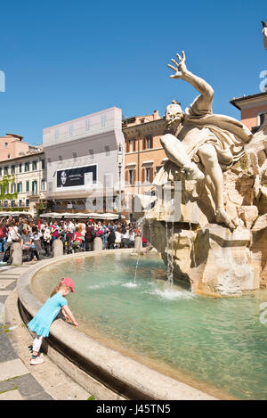 Fontana dei Quattro Fiumi ou Fontaine des Quatre Fleuves sur la Piazza Navona (Rome) avec une petite fille enfant jouant dans l'eau sur une journée ensoleillée. Banque D'Images