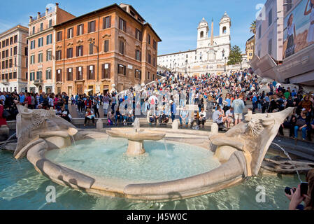 Place d'Espagne à Rome avec les touristes sur une journée ensoleillée avec ciel bleu de l'église Trinità dei Monti en arrière-plan et fontaine de l'affreux voile avant-plan. Banque D'Images