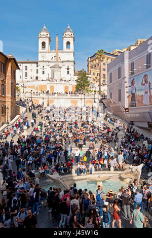 Place d'Espagne à Rome avec des foules de touristes sur une journée ensoleillée avec ciel bleu en arrière-plan de l'église Trinità dei Monti Fontaine de l'affreux voile avant-plan. Banque D'Images