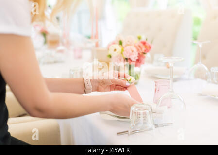 Décor de mariage fleurs fleuriste la préparation en restaurant en plein air. Pas de visage, set de table pour les vacances. Banque D'Images