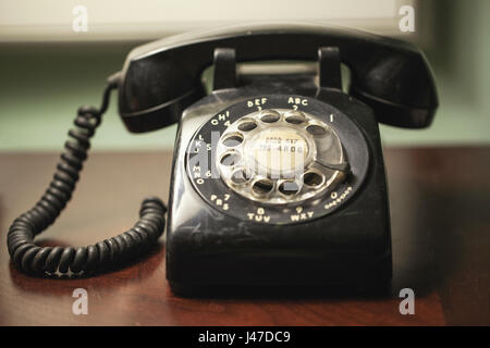 Vintage Retro Antique téléphone rotatif noir sur un bureau de filet Banque D'Images