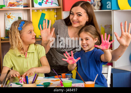 Petite fille aux étudiants la peinture au doigt en art school class. Banque D'Images