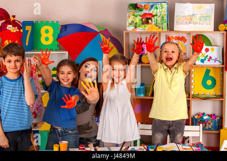 Petite fille aux étudiants la peinture au doigt en art school class. Banque D'Images