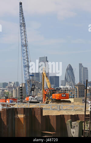 Projet Thames Tideway, Londres. Une grue excavatrice et se tiennent sur un batardeau temporaire aux chambres Wharf, London Bridge. Ville de ville de Londres au-delà. Banque D'Images