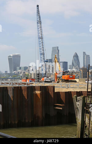 Projet Thames Tideway, Londres. Une grue excavatrice et se tiennent sur un batardeau temporaire aux chambres Wharf, London Bridge. Ville de ville de Londres au-delà. Banque D'Images