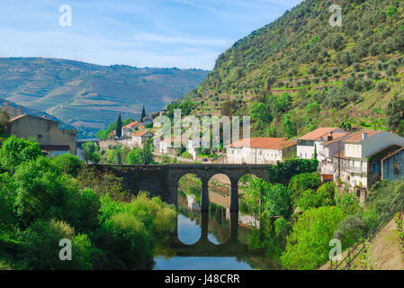 Vallée du Douro Portugal, vue de la ville de Pinhao dans la région du Douro montrant le vieux pont romain qui enjambe la rivière Pinhao, Portugal. Banque D'Images