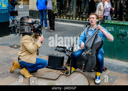 GLASGOW, Ecosse 10 Mai 2017 : Le violoncelliste/singer/songwriter, Paisley né INGRAM CALUM Rue tout en étant filmé pour un documentaire Dans Buchanan Street, Banque D'Images