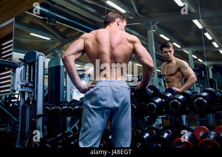 Vue arrière d'un homme sportif avec les muscles dans la salle de sport Banque D'Images