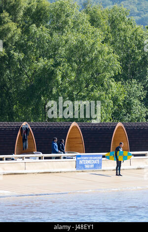 Un surfeur holding surf board à la piscine à vagues artificielles dans la vallée de Conwy sait aussi surfer sur Snowdonia, avec l'hébergement glamping chalets Banque D'Images