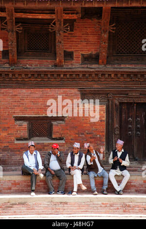 Les hommes assis dans une rangée, sur une étape à Patan Durbar Square, Patan Lalitpur Kathmandu Népal Banque D'Images