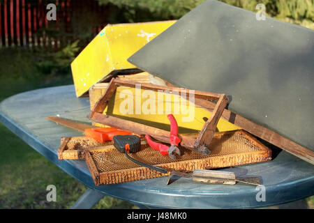 Divers outils à main et des pièces d'une ruche sur la table outdoor Banque D'Images