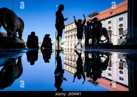 Munich, Allemagne. 10 mai, 2017. Les gens et le ciel bleu de refléter dans une flaque à la place Odeonsplatz à Munich, Allemagne, 10 mai 2017. Photo : Peter Kneffel/dpa/Alamy Live News Banque D'Images