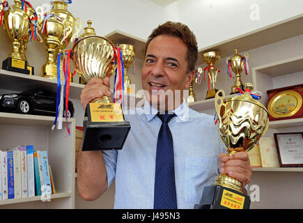 (170511) -- YIWU, 11 mai 2017 (Xinhua) -- homme d'affaires iranien Hamid Dehgh montre son championnat tasses des courses dans son bureau dans la ville de Yiwu, Province de Zhejiang, Chine orientale, le 8 mai 2017. La course et la pêche sont les passe-temps d'Hamid dans ses temps libres. Hamid, 52 ans, est venu à Shanghai en 2003 pour gérer une entreprise sur l'importation des foulards en soie iranien, et une société a été fondée par Hamid et son épouse chinoise en 2007, avec des liens d'affaires actuellement élargie à de nombreuses villes en Asie, en Europe et en Amérique du Nord. Hamid s'est installé dans le centre-ville de Shanghai. Il ne pouvait parler le chinois couramment et a envoyé son daught Banque D'Images