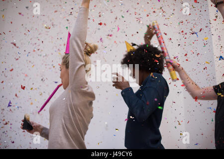 Multiethnics parti confettis jeunes heureux nouvel an fête de groupe en dansant et s'amuser à la maison Banque D'Images