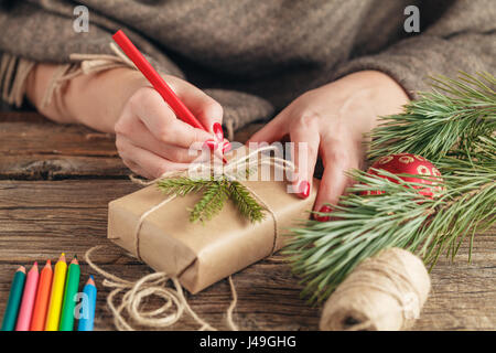 Fond de Noël. voir des mains écrit sur boîte-cadeau. Paniers-cadeaux et des parchemins, des branches d'épinette sur table en bois miteux. Lieu de travail pour la préparation de Han Banque D'Images