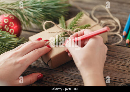 Fond de Noël. voir des mains écrit sur boîte-cadeau. Paniers-cadeaux et des parchemins, des branches d'épinette sur table en bois miteux. Lieu de travail pour la préparation de Han Banque D'Images