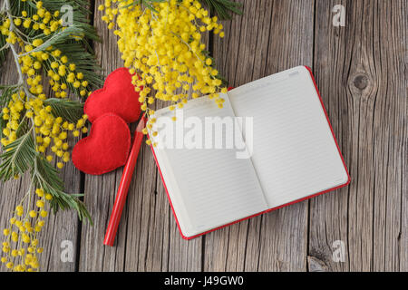 Table en bois en milieu rural avec un ordinateur portable et de l'amour message, fleurs de printemps jaune Banque D'Images