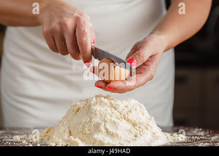 La cuisson fait maison, cuisine scène montrant le beurre, farine, sucre et graines de vanille d'être mélangés pour faire des biscuits sablés, avec des mains de femme. Banque D'Images