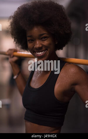 Beaux jeunes african american woman in sport fitness bar vide de levage Banque D'Images